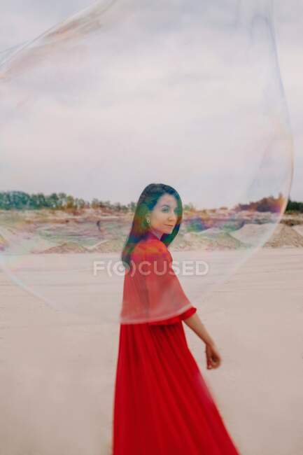 Woman dancing with big soap bubble in the desert — Stock Photo