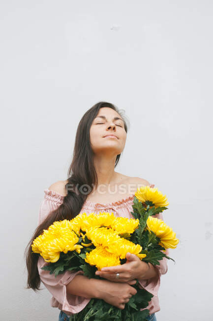 Frau mit einem Strauß gelber Chrysanthemen — Stockfoto