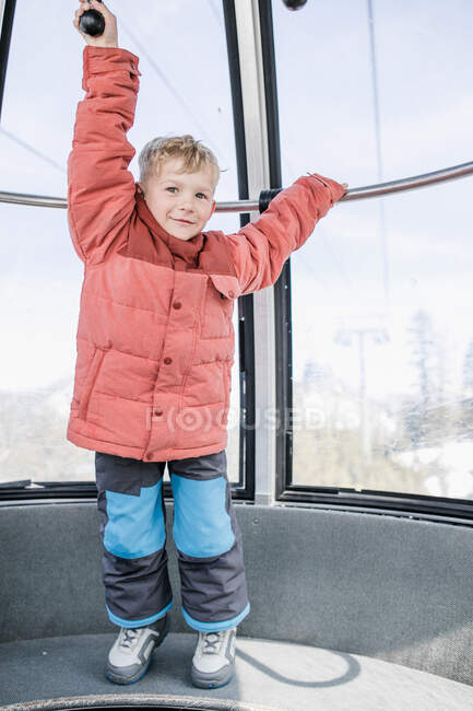 Boy standing in a overhead cable car holding onto a railing, Mammoth Lakes, California, USA — Fotografia de Stock
