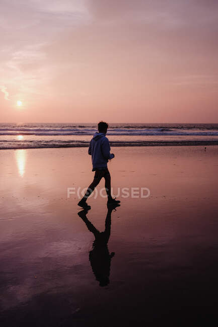 Хлопець, що йшов по пляжу на заході сонця, пункт Дана, каліфорнія, уса. — стокове фото