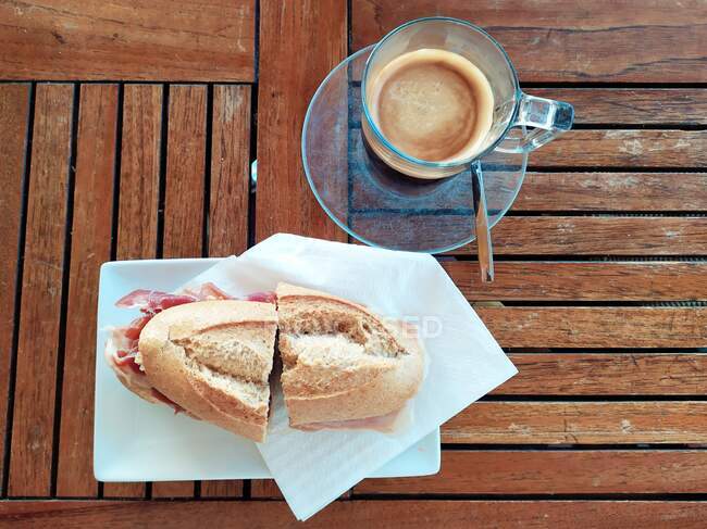 Baguette mit Serrano-Schinken und eine Tasse Kaffee — Stockfoto
