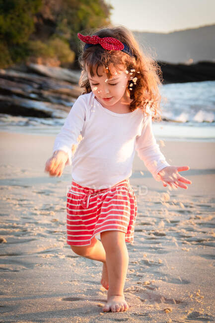 Девушка на пляже играет с песком, Бразилия — стоковое фото