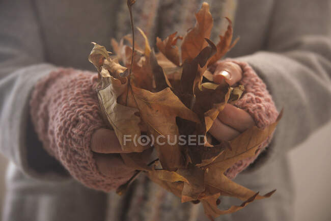 Frau trägt fingerlose Handschuhe mit Herbstblättern — Stockfoto