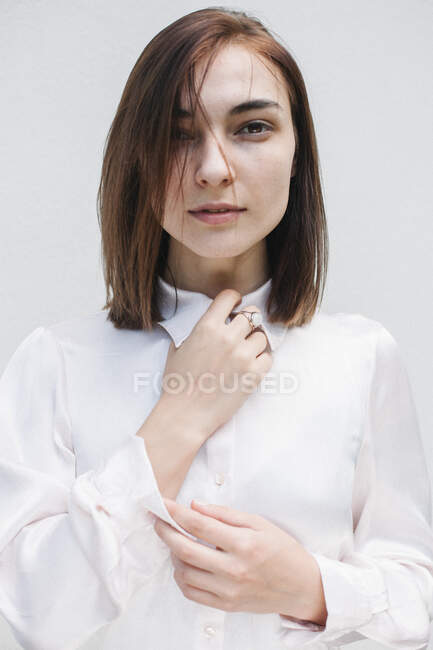 Portrait of a beautiful woman holding her shirt collar — Stock Photo