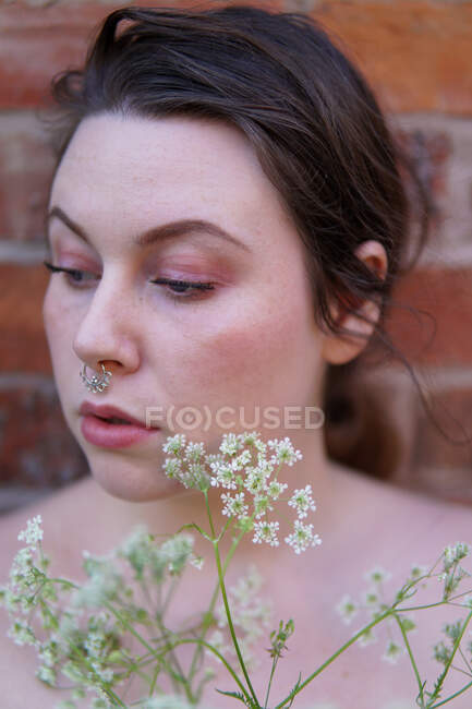 Portrait d'une belle femme tenant des fleurs — Photo de stock