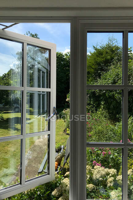 View of a country garden through a window, England, UK — Stock Photo
