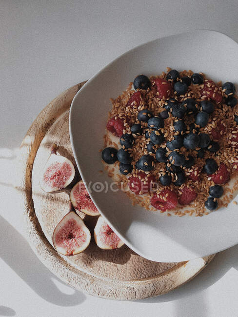 Oatmeal with blueberries, raspberries, figs and linseeds — Stock Photo