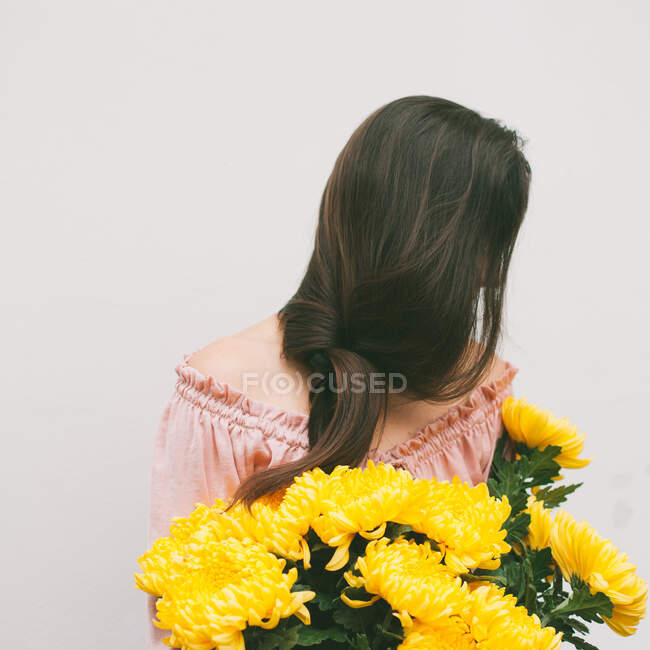 Portrait d'une femme tenant un bouquet de fleurs de chrysanthème jaune — Photo de stock