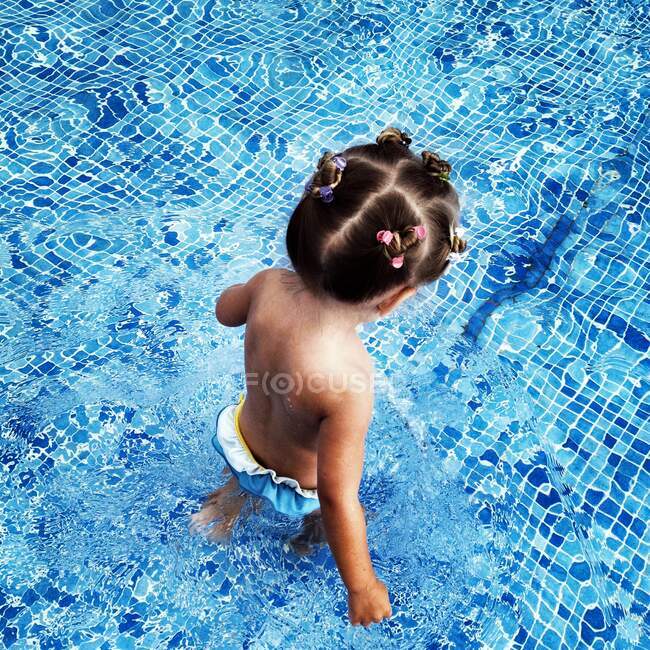 Overhead view of a girl standing in a swimming pool — Stock Photo