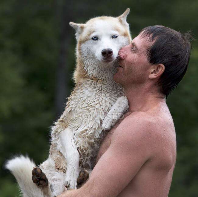 Mann umarmt seinen Hund nach dem Schwimmen — Stockfoto