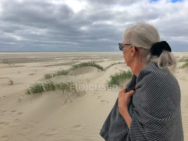 Donna anziana in spiaggia avvolta in un asciugamano dopo una nuotata, Fanoe, Danimarca — Foto stock