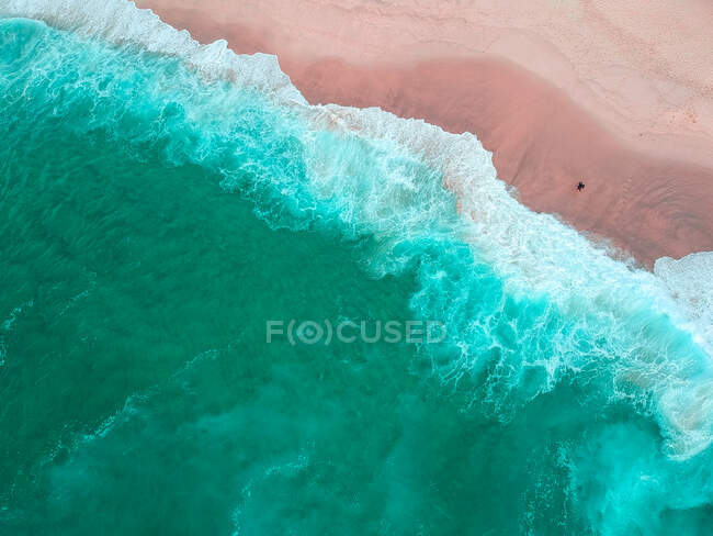 Vista aerea della costa sabbiosa e del mare ondulato nella giornata di sole — Foto stock