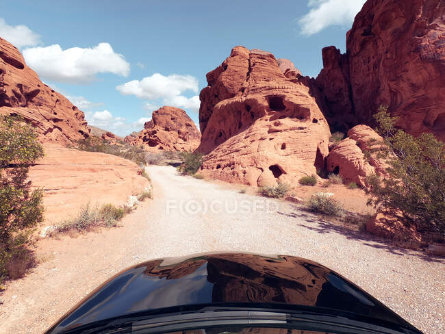 Автомобиль едет по пустынной дороге, долина Файр-стейт-парк, Невада, США — стоковое фото