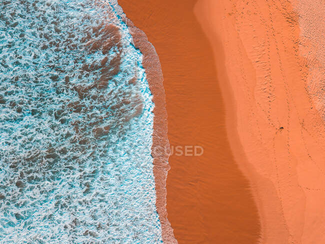 Vue aérienne de la côte sablonneuse et de la mer ondulée par temps ensoleillé — Photo de stock