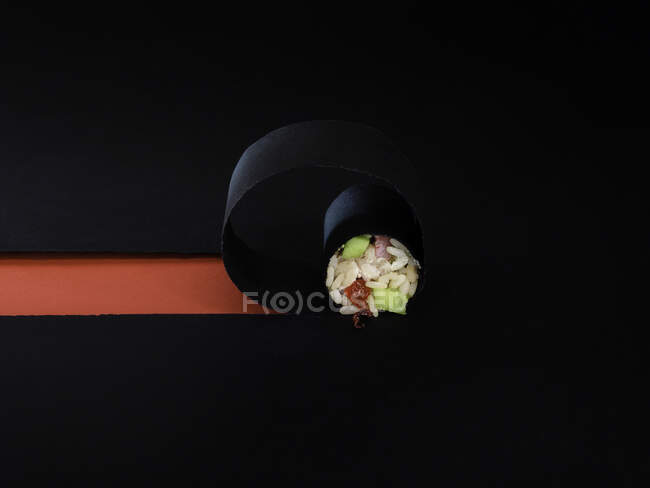 Rollo de sushi con caviar rojo sobre fondo negro - foto de stock