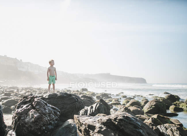 Junge steht auf Felsen am Strand, Laguna Beach, Kalifornien, Vereinigte Staaten — Stockfoto