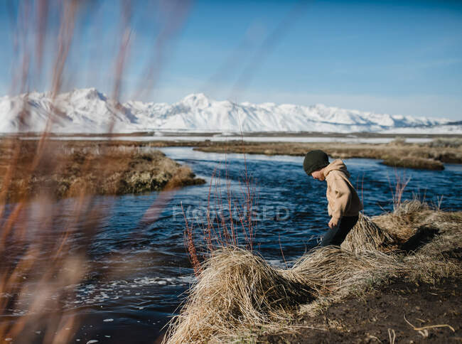 Boy standing by a river, Mammoth Lakes, California, Estados Unidos - foto de stock