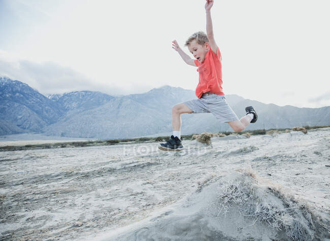Boy running along a desert trail, Palm Springs, Califórnia, Estados Unidos — Fotografia de Stock