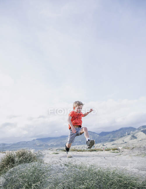 Boy running along a desert trail, Palm Springs, California, United States — Stock Photo