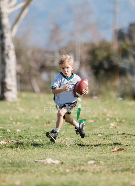 Boy playing flag football, California, Estados Unidos - foto de stock