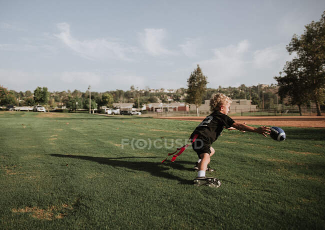 Мальчик играет в футбол с мячом, Калифорния, США — стоковое фото