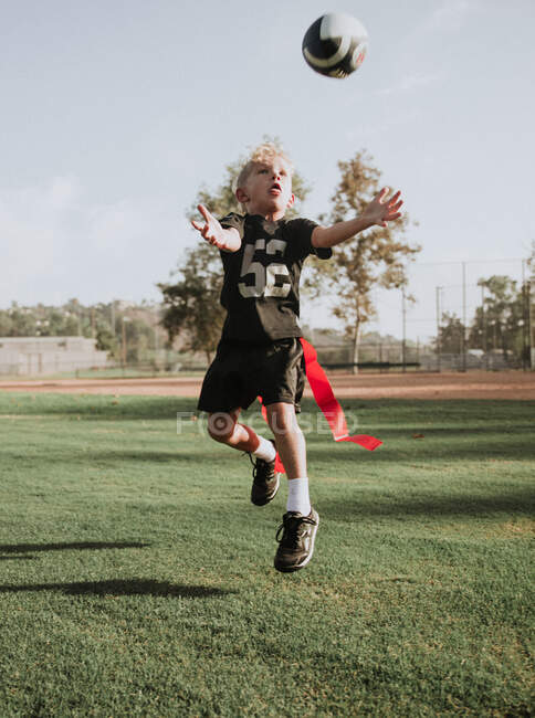 Мальчик играет в футбол, ловит мяч, Калифорния, США — стоковое фото