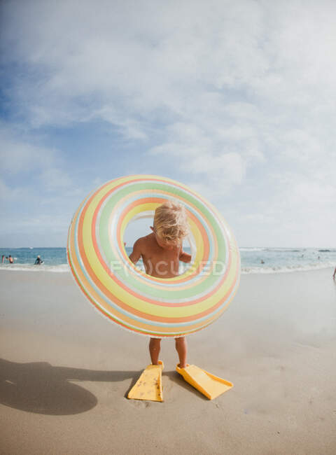 Junge mit Schwimmflossen und aufblasbarem Gummiring am Strand, Laguna Beach, Kalifornien, Vereinigte Staaten — Stockfoto
