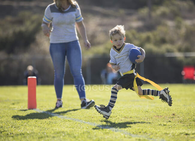 Mother watching her son score a touchdown in flag football, California, United States — Stock Photo
