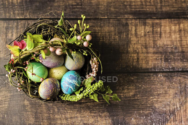 Ovos de Páscoa em uma cesta em uma mesa de madeira — Fotografia de Stock