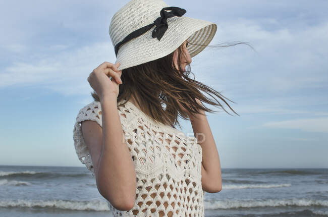 Adolescente de pé na praia segurando seu chapéu, Argentina — Fotografia de Stock