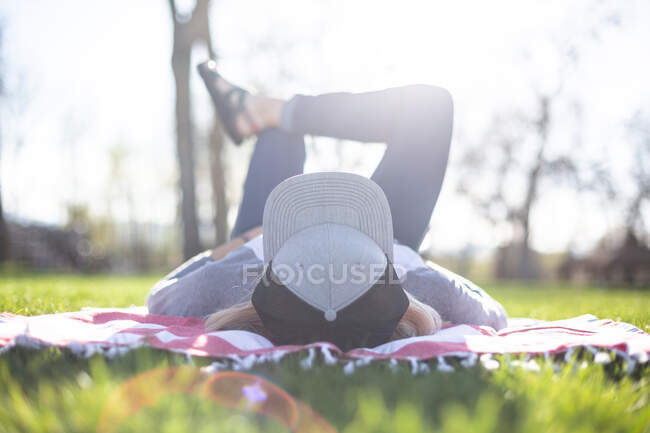 Mulher deitada em um cobertor no jardim — Fotografia de Stock