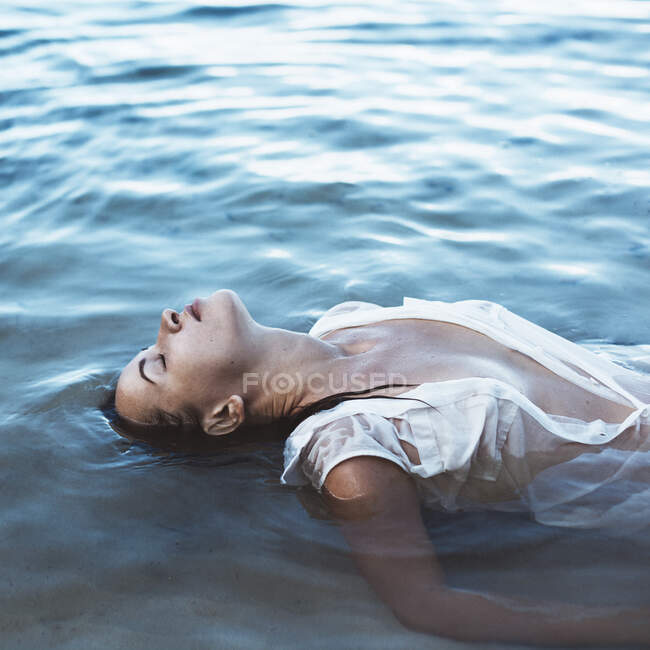 Donna sdraiata sulla schiena in mare, Seychelles — Foto stock