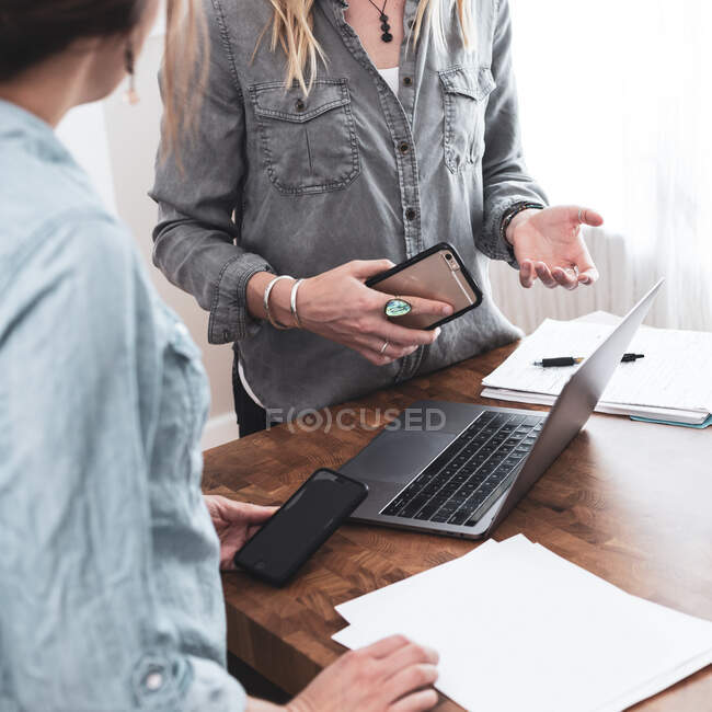 Two businesswomen standing in an office having a discussion — Stock Photo