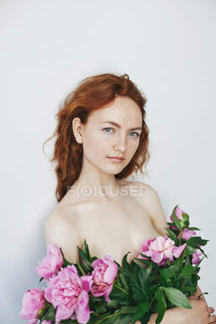 Ritratto di una giovane donna con peonie in mano — Foto stock