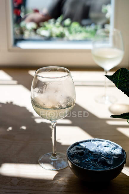 Two glasses of white wine and a blue spirulina smoothie bowl — Stock Photo