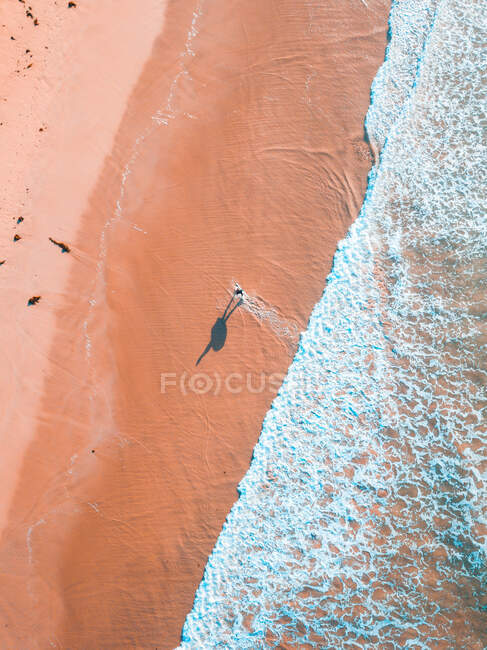Вид с воздуха на человека с серфингом прогуливаясь по Тринадцатому пляжу, Виктория, Австралия — стоковое фото