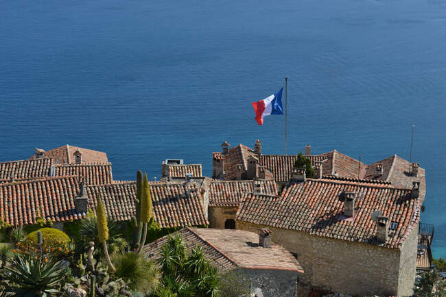 Pintoresca foto de la antigua ciudad de Francia con bandera sobre los tejados - foto de stock