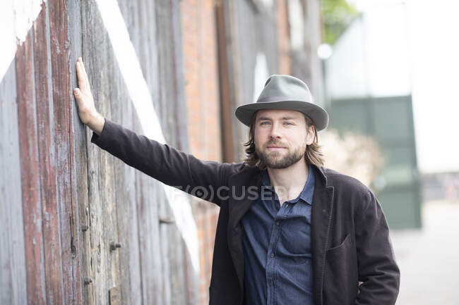 Portrait of a man leaning against a building — Stock Photo