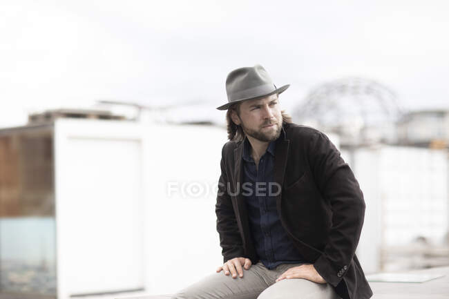 Portrait of a man sitting outdoors on a wall — Stock Photo