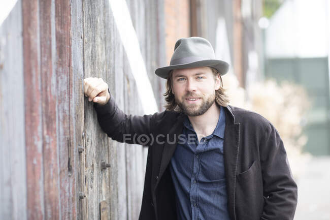 Portrait of a man leaning against a building — Stock Photo