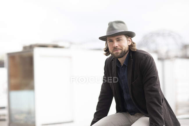 Portrait of a man sitting outdoors on a wall — Stock Photo