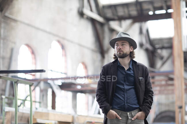 Портрет человека, стоящего в отреставрированном здании — стоковое фото