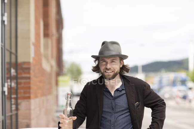 Ritratto di un uomo sorridente che tiene in mano una bottiglia d'acqua — Foto stock
