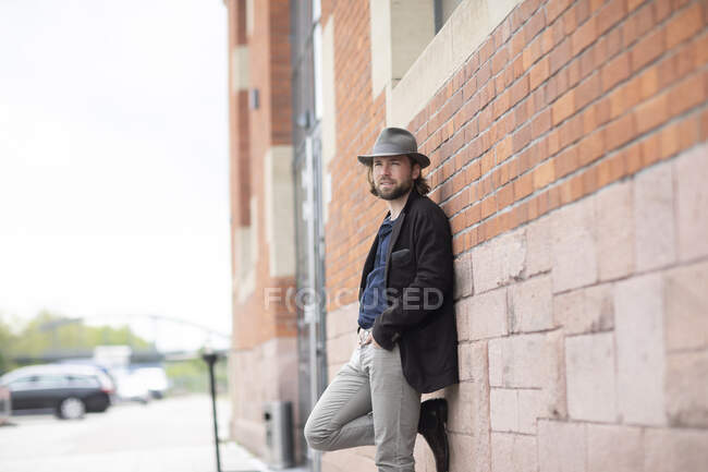 Portrait of a man leaning against a wall — Stock Photo