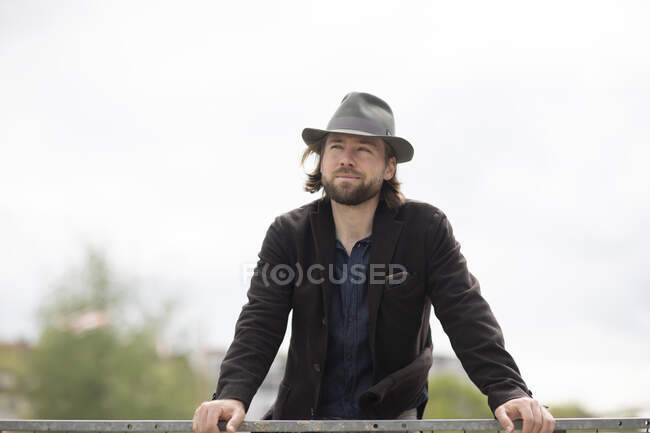 Retrato de um homem em pé ao ar livre apoiado em uma parede — Fotografia de Stock