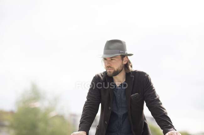 Retrato de um homem em pé ao ar livre apoiado em uma parede — Fotografia de Stock