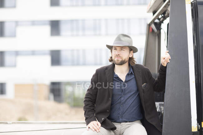 Porträt eines Mannes, der auf dem Rücken eines Lastwagens sitzt — Stockfoto