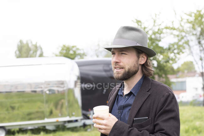 Portrait of a man standing outdoors holding a cup of coffee — Stock Photo