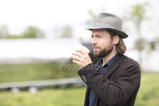 Retrato de um homem de pé ao ar livre bebendo uma xícara de café — Fotografia de Stock