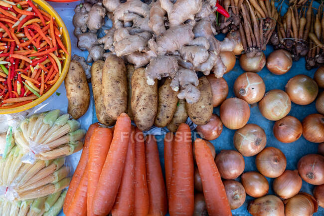 Vista aérea de cebolla, zanahoria, papa, jengibre y chile en un mercado, Tailandia - foto de stock